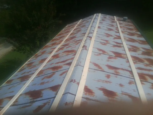 Rusted metal roof panels with new wood purlins before replacement — Storm Damage Roof Repair in Hillister by Roofing Brothers