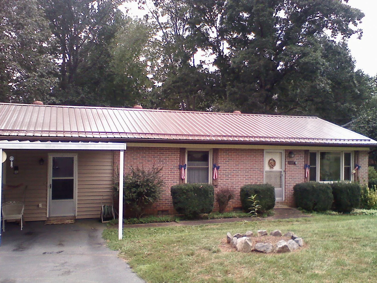 Bronze metal roof and carport on a brick ranch home — Roof Repair work by our crew in Hillister
